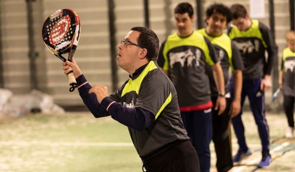 Personas adultas con discapacidad practicando pádel.