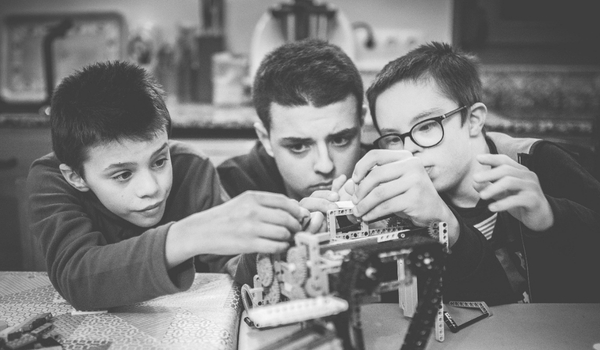 Niños con discapacidad montando legos de robótica.